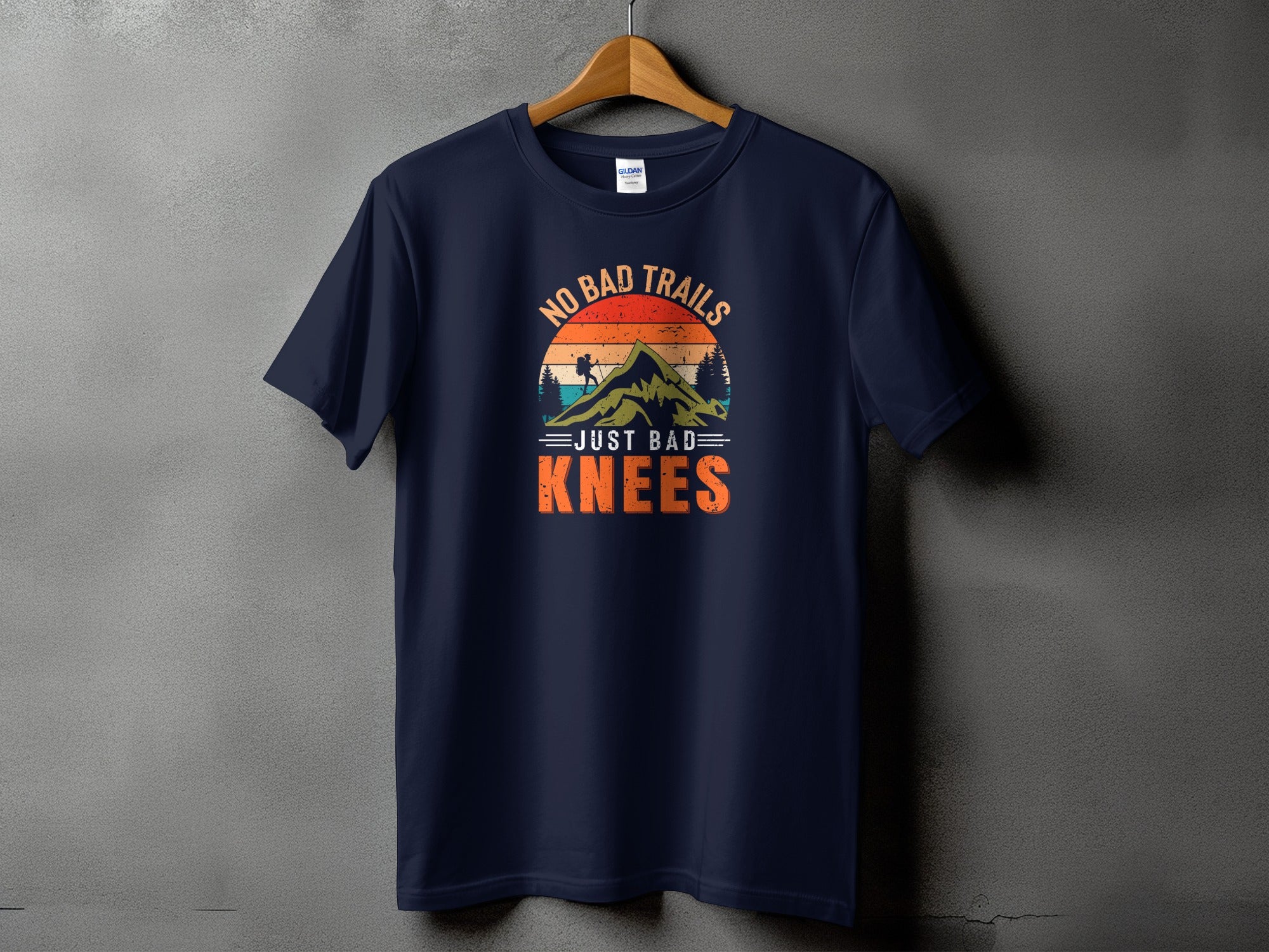 Navy t-shirt with graphic "No Bad Trails Just Bad Knees" and mountain silhouette.