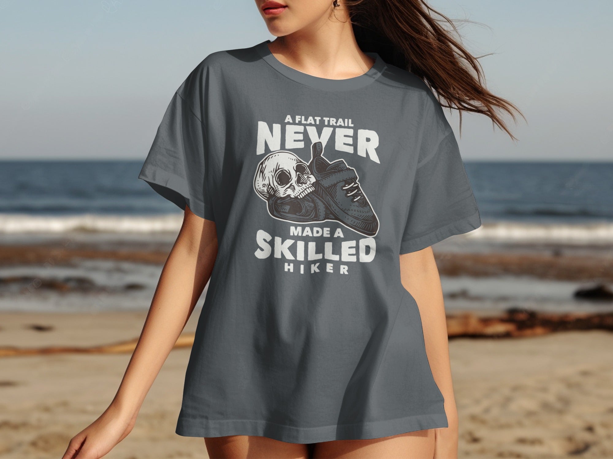 T-shirt with text "A flat trail never made a skilled hiker" and skull graphic.
