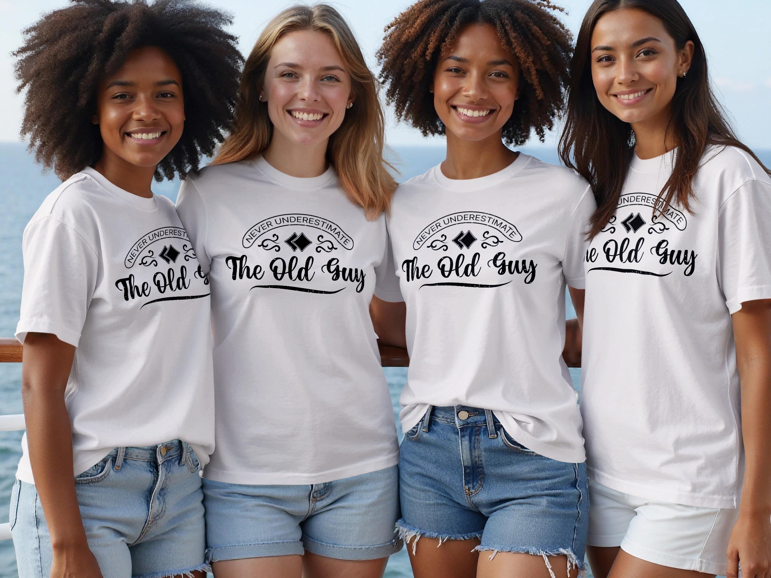 Four smiling women wear white t-shirts with "The Old Guy" text.