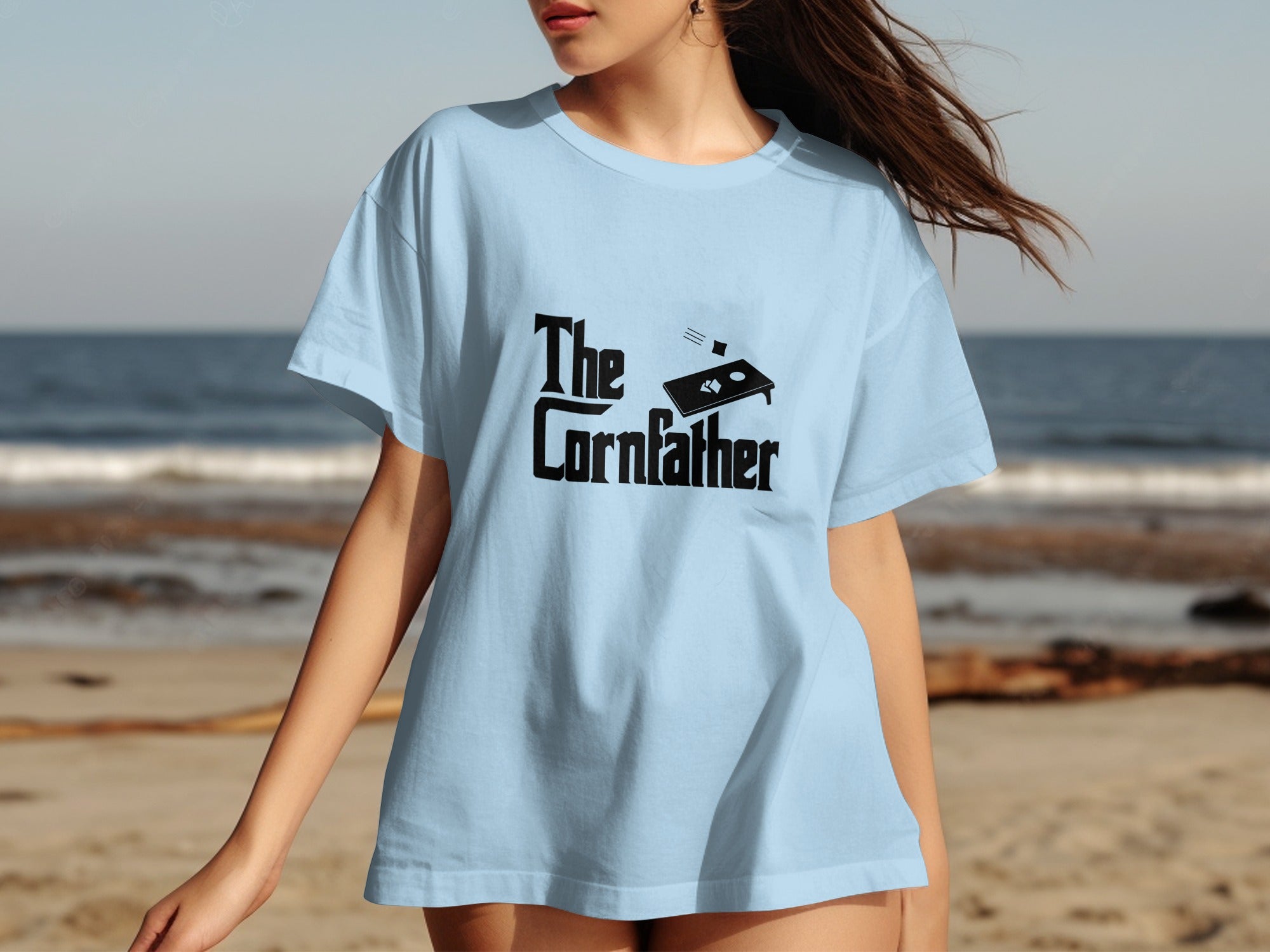 Light blue t-shirt with black "The Cornfather" text and cornhole graphic.
