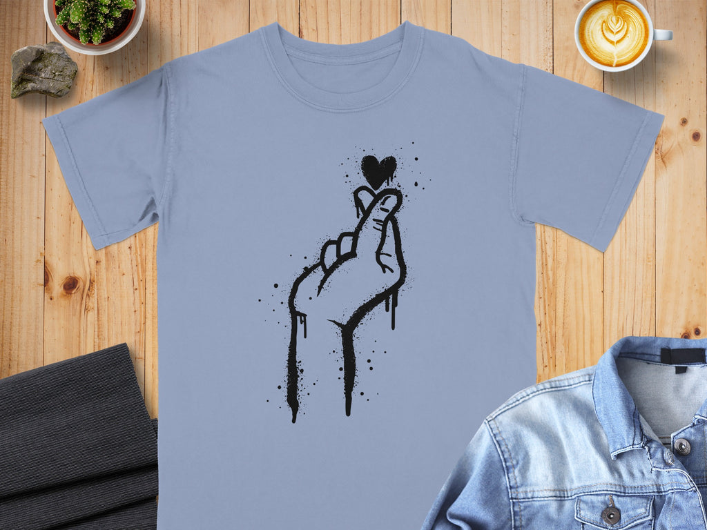 Pale blue t-shirt with a black spray-painted heart gesture design.
