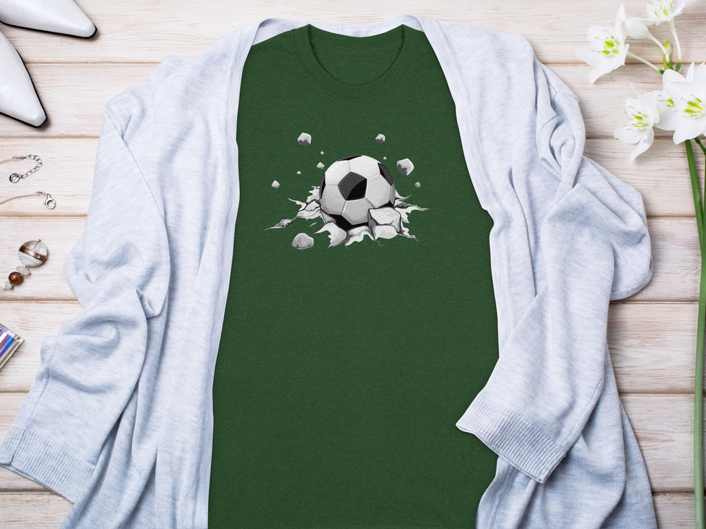 Green t-shirt with a soccer ball breaking through a cracked surface graphic.