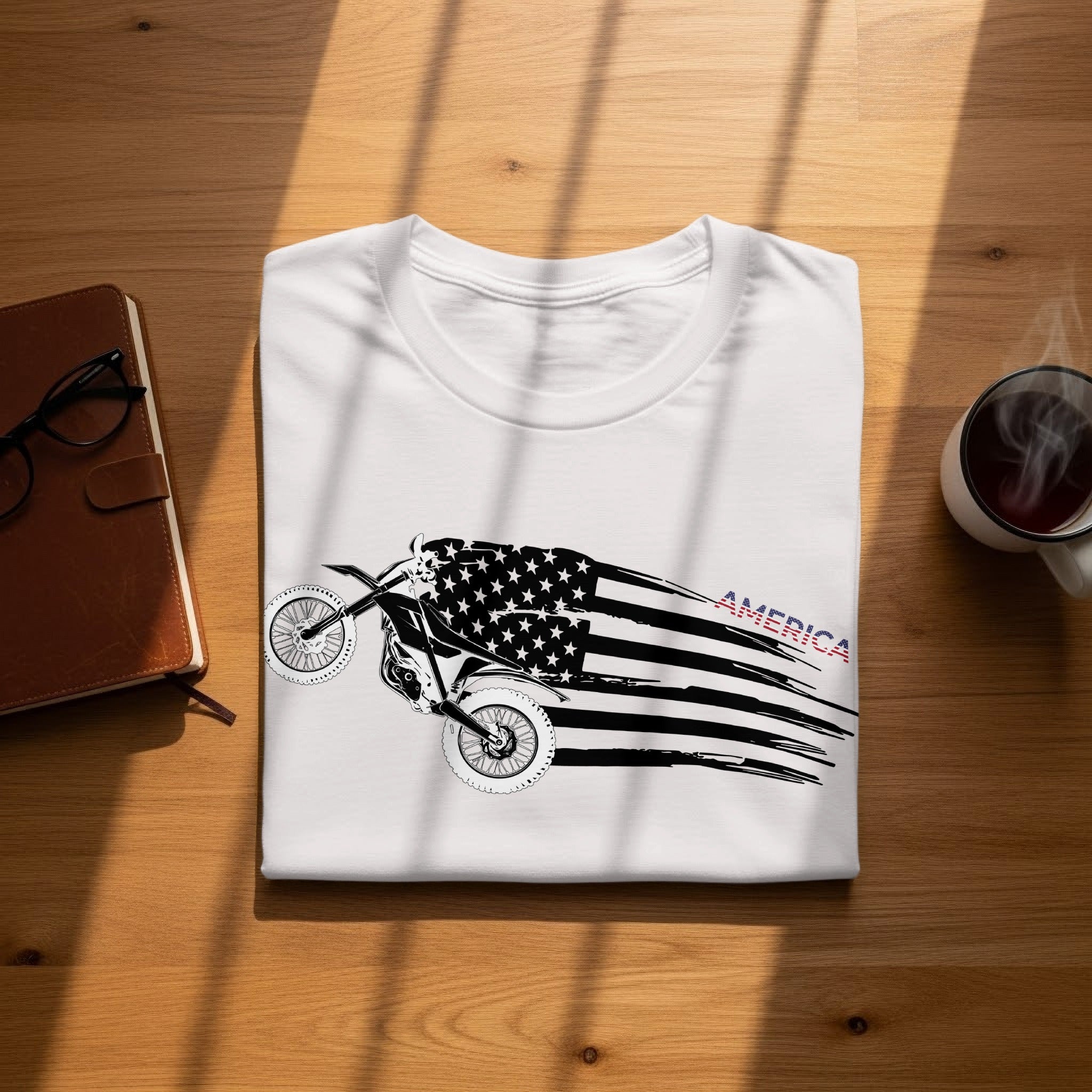 White t-shirt with a dirt bike and American flag graphic, says "AMERICA".