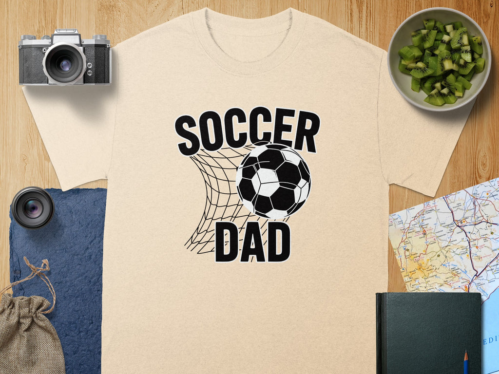 Light beige t-shirt with black "Soccer Dad" text and soccer ball in a net graphic.