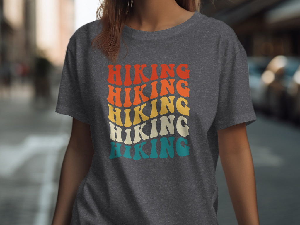 Dark grey t-shirt with stacked retro text "HIKING" in red, orange, yellow, cream, and teal.