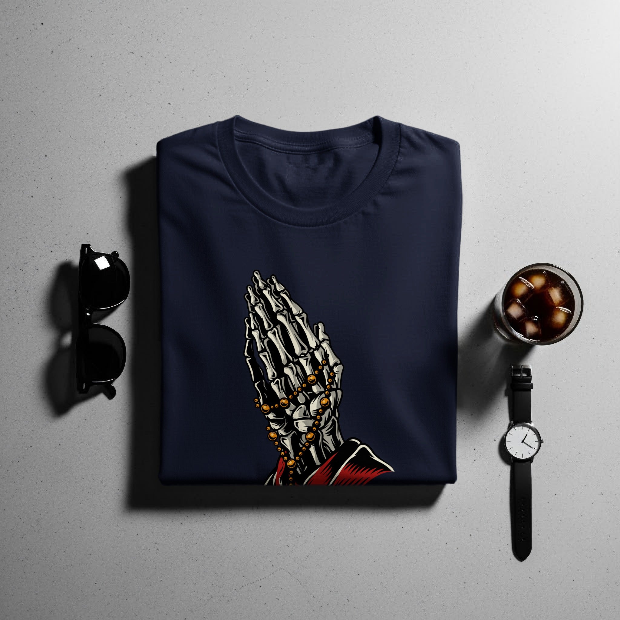 Navy t-shirt with skeleton praying hands graphic and gold beads.