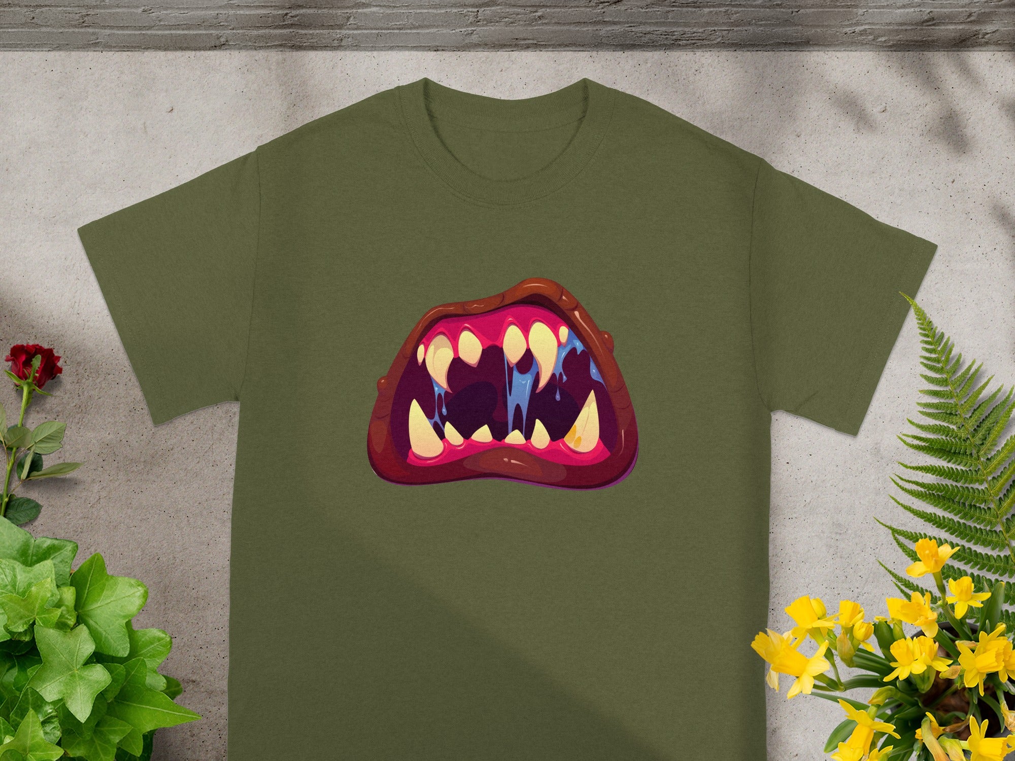 Green t-shirt with a cartoon mouth graphic featuring sharp teeth and blue drool.