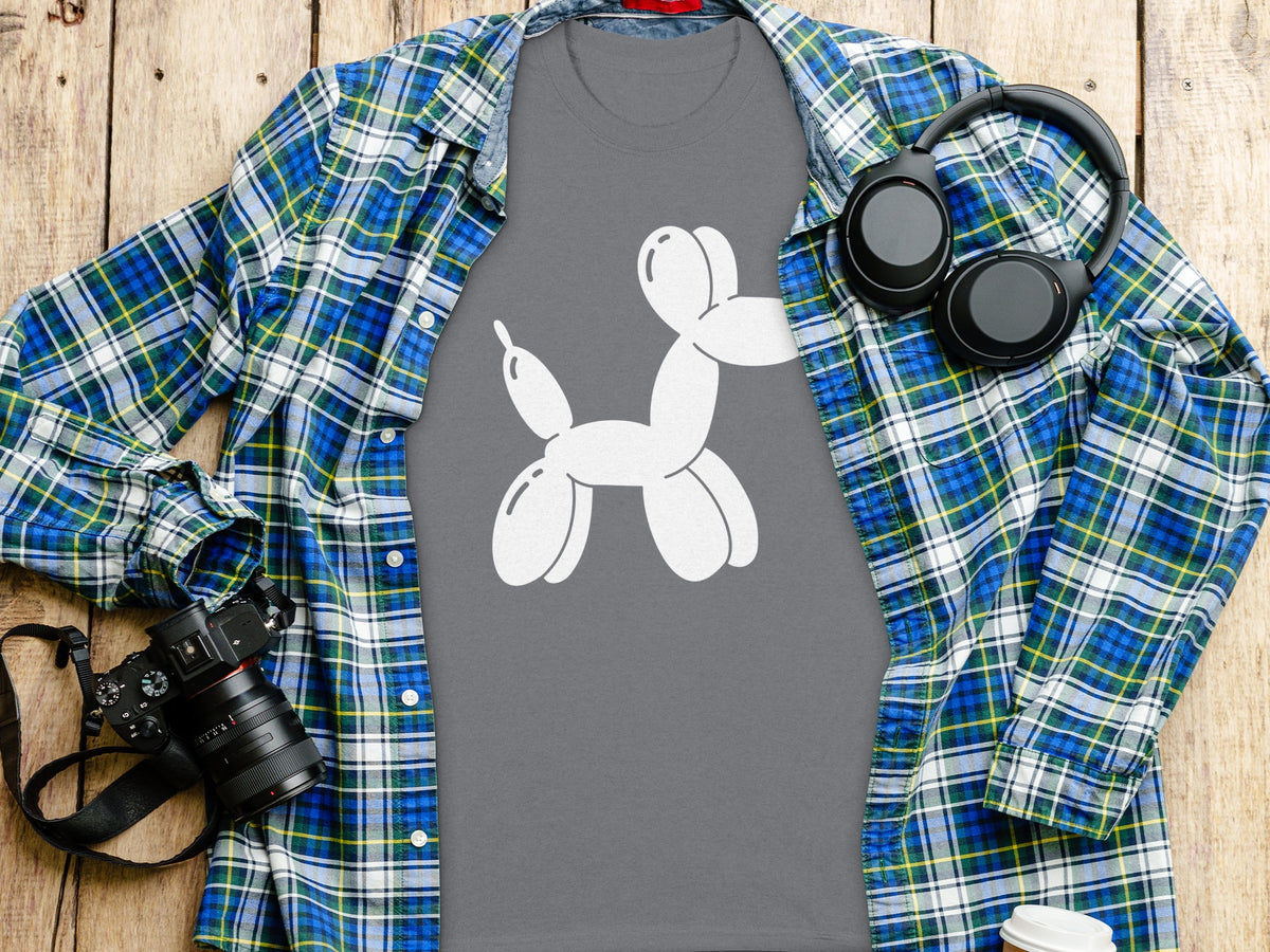 Gray t-shirt with white balloon dog graphic, open plaid shirt, headphones, and camera.