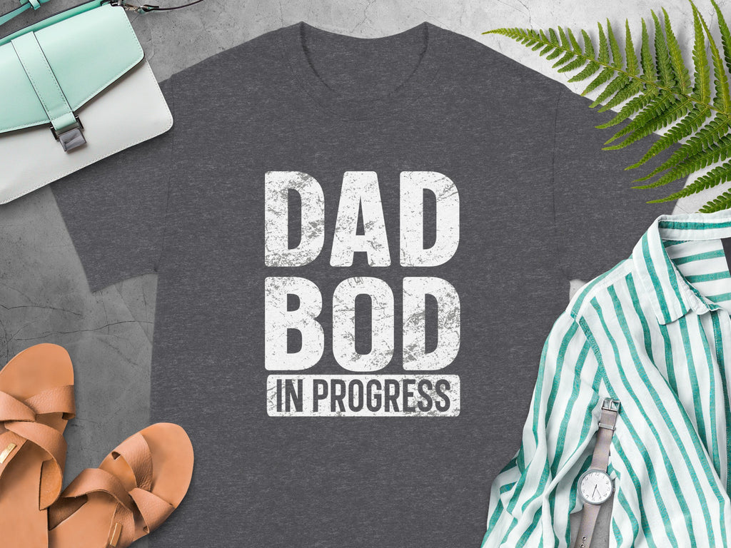 Dark grey t-shirt with white text "DAD BOD IN PROGRESS".