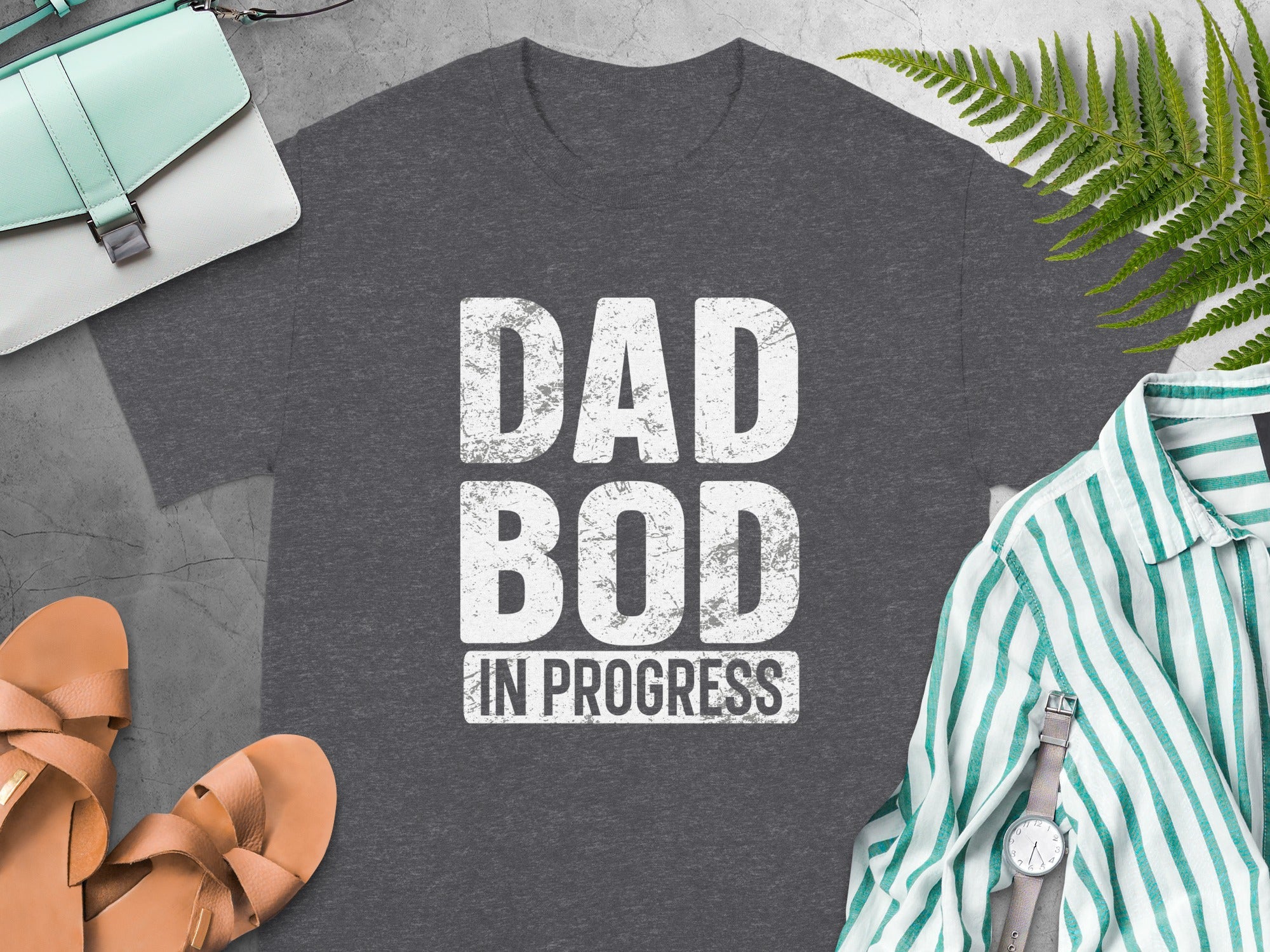 Dark grey t-shirt with white text "DAD BOD IN PROGRESS".