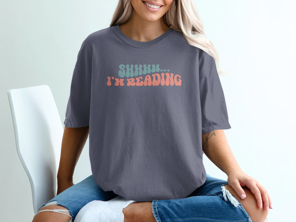Dark grey t-shirt with "SHHHH... I'M READING" text in retro font.