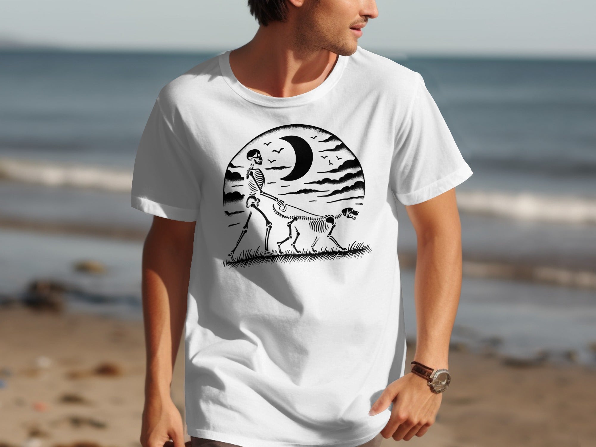 White t-shirt featuring a skeleton walking a skeleton dog under a crescent moon and birds.