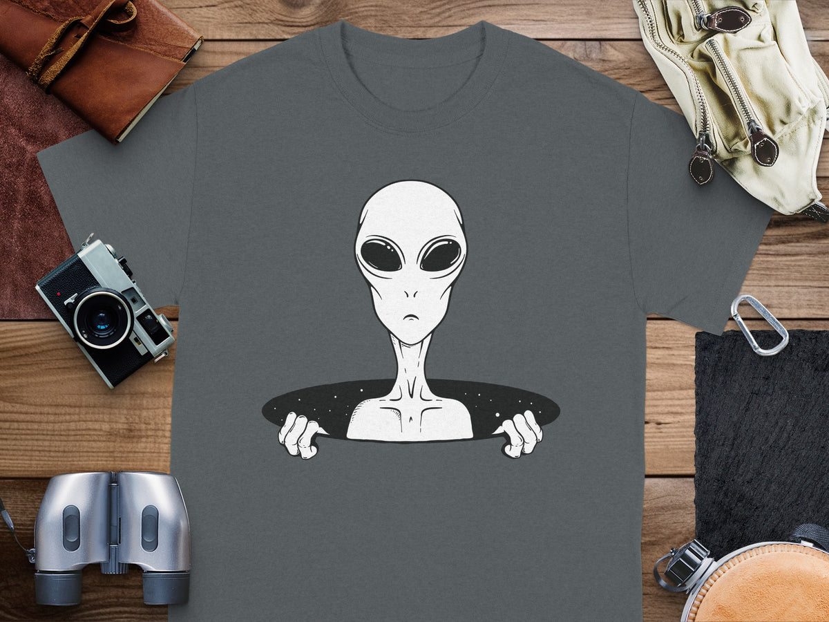 T-shirt with a grey alien peeking through a starry hole.
