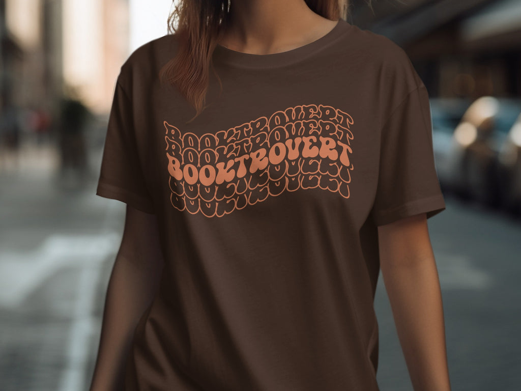 Brown t-shirt with "Booktrovert" in wavy, stacked orange lettering.