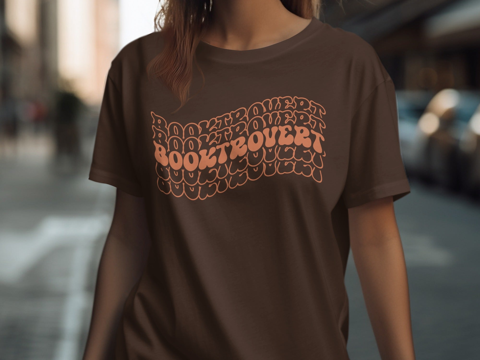 Brown t-shirt with "Booktrovert" in wavy, stacked orange lettering.
