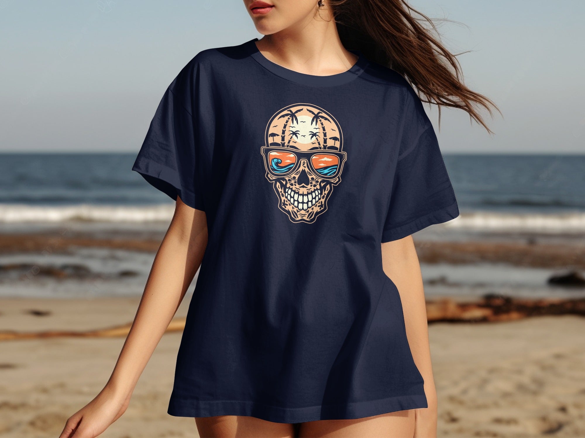 Dark navy t-shirt with skull graphic wearing sunglasses on a beach background.