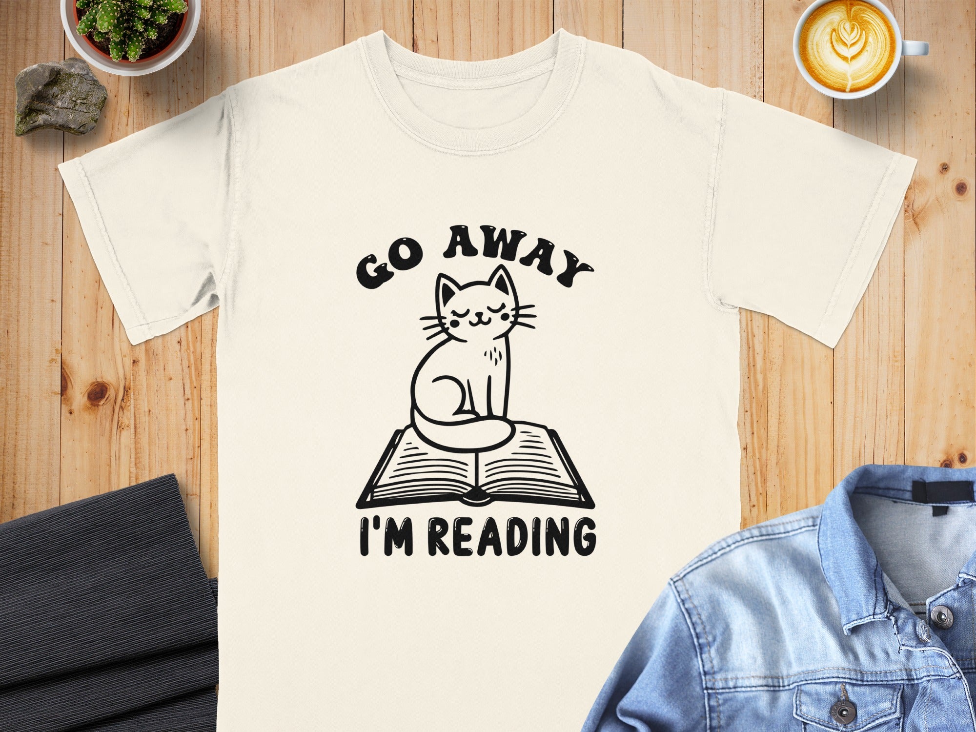 Cream t-shirt with cat on book graphic and text "GO AWAY I'M READING".