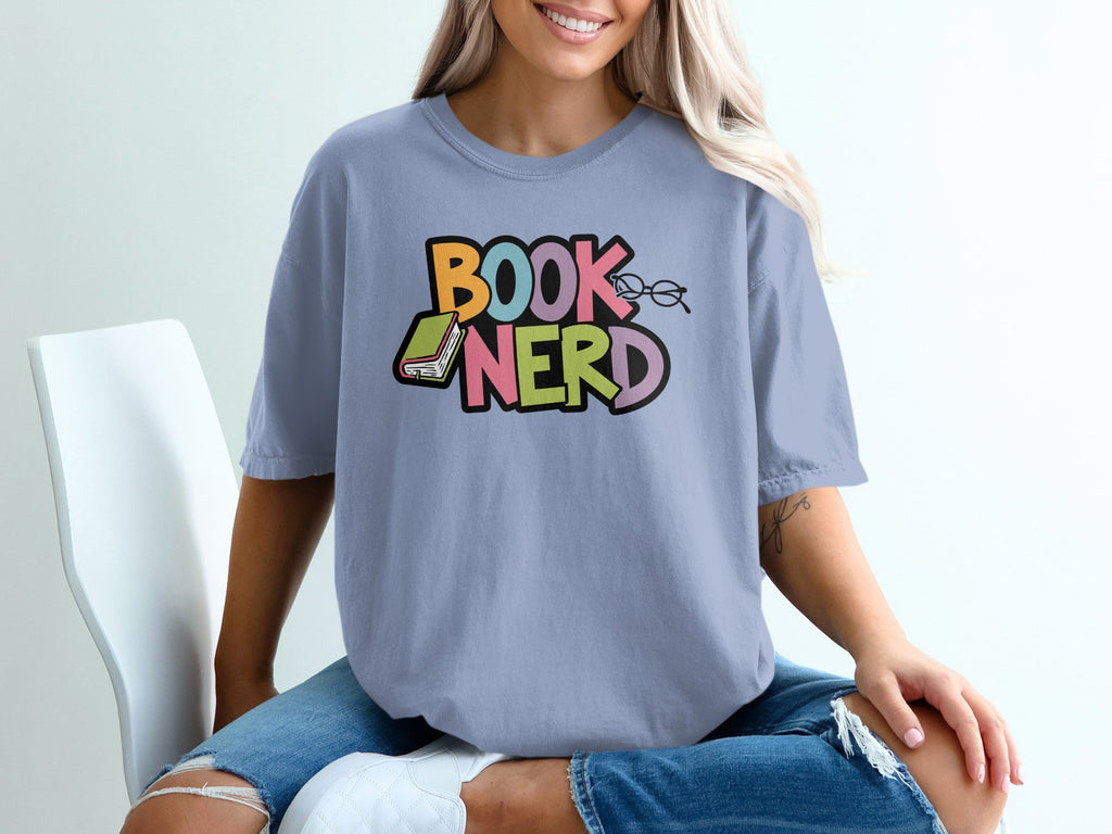 Light blue t-shirt with colorful "BOOK NERD" text, glasses, and a book graphic.