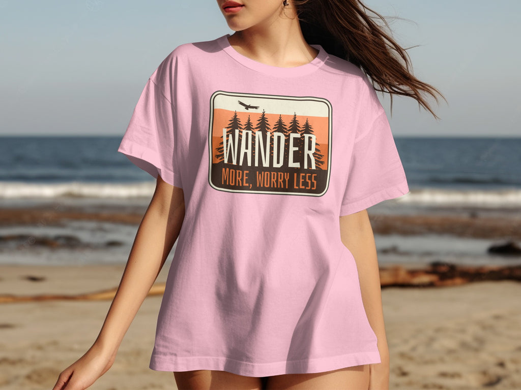 Pink t-shirt with "WANDER MORE, WORRY LESS" desert landscape graphic.