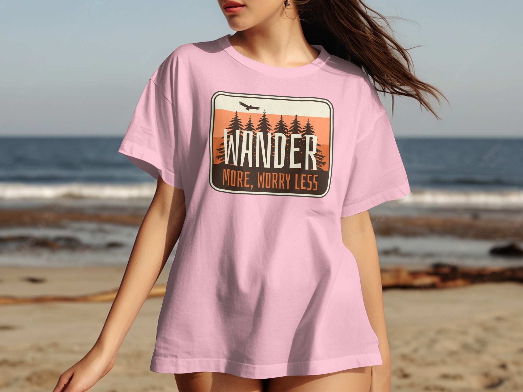 Pink t-shirt with "WANDER MORE, WORRY LESS" desert landscape graphic.