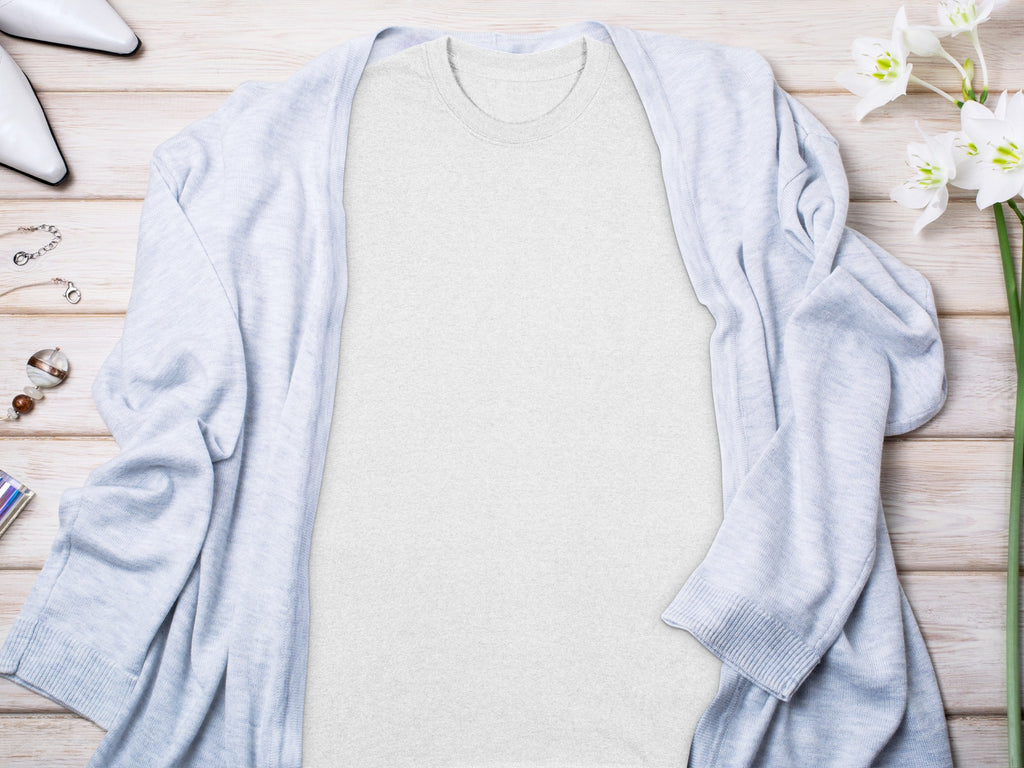 Light gray t-shirt with light blue cardigan, white shoes, and necklace.