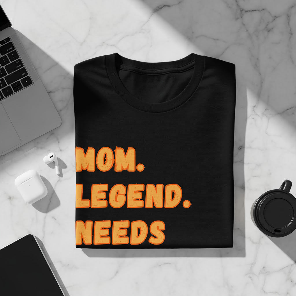Black t-shirt with orange text reading "MOM. LEGEND. NEEDS."