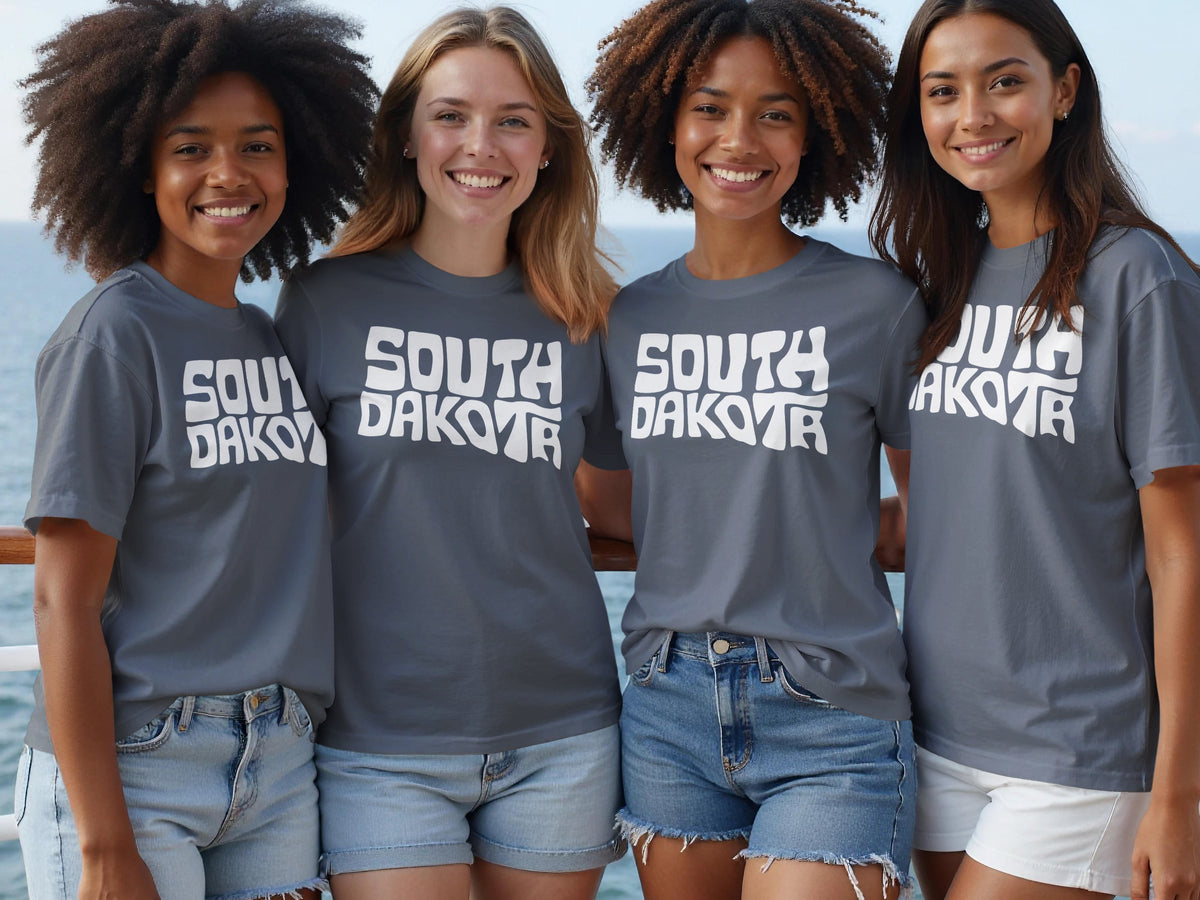 Four young women wear grey t-shirts with "South Dakota" in white text.