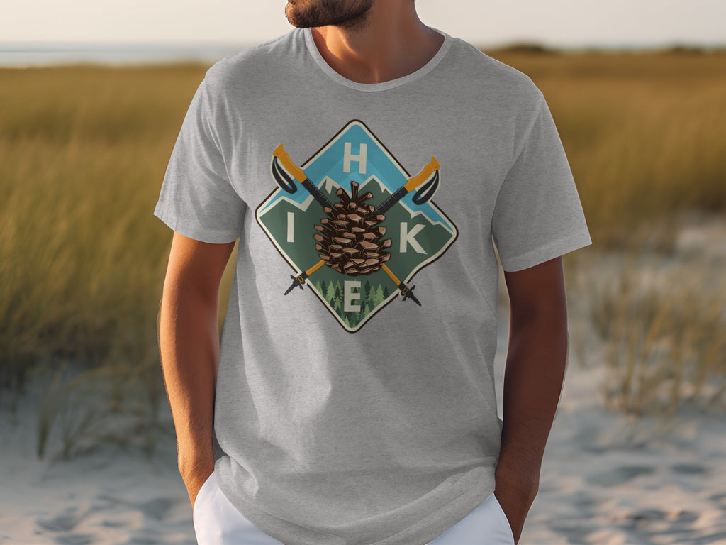 Grey t-shirt with a diamond graphic featuring a pine cone, mountains, and the letters H, I, K, E.