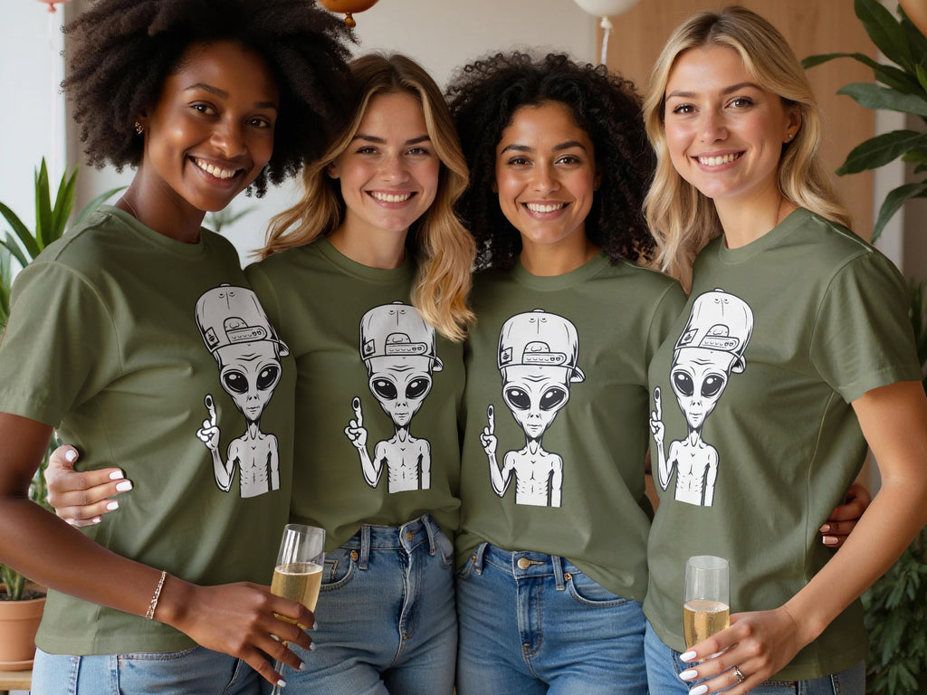 Four women in olive green t-shirts featuring alien graphics and blue jeans, holding champagne flutes.