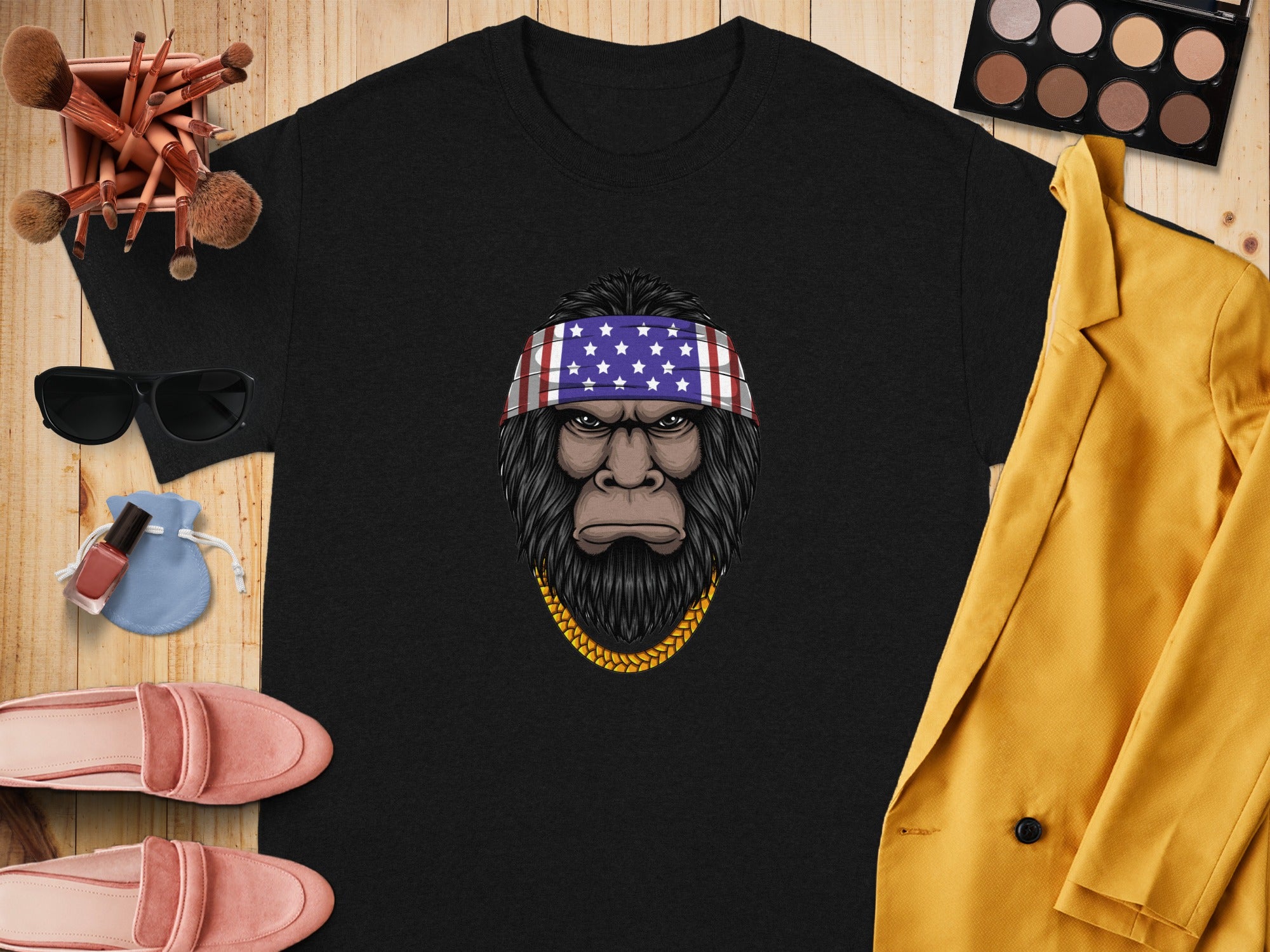 Black t-shirt featuring a Bigfoot head graphic with an American flag bandana and gold chain.