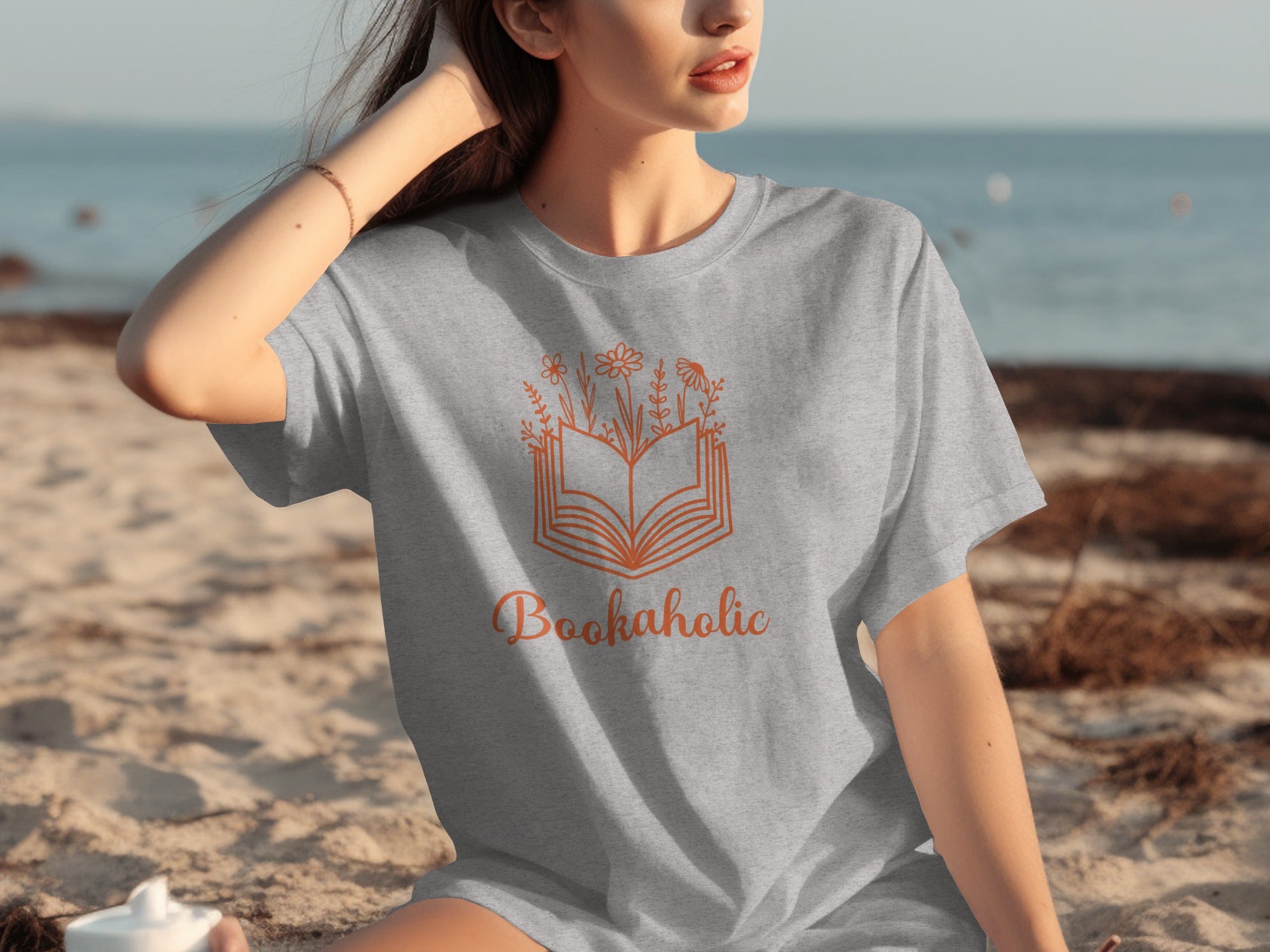 Gray t-shirt with open book and flowers graphic, text "Bookaholic"