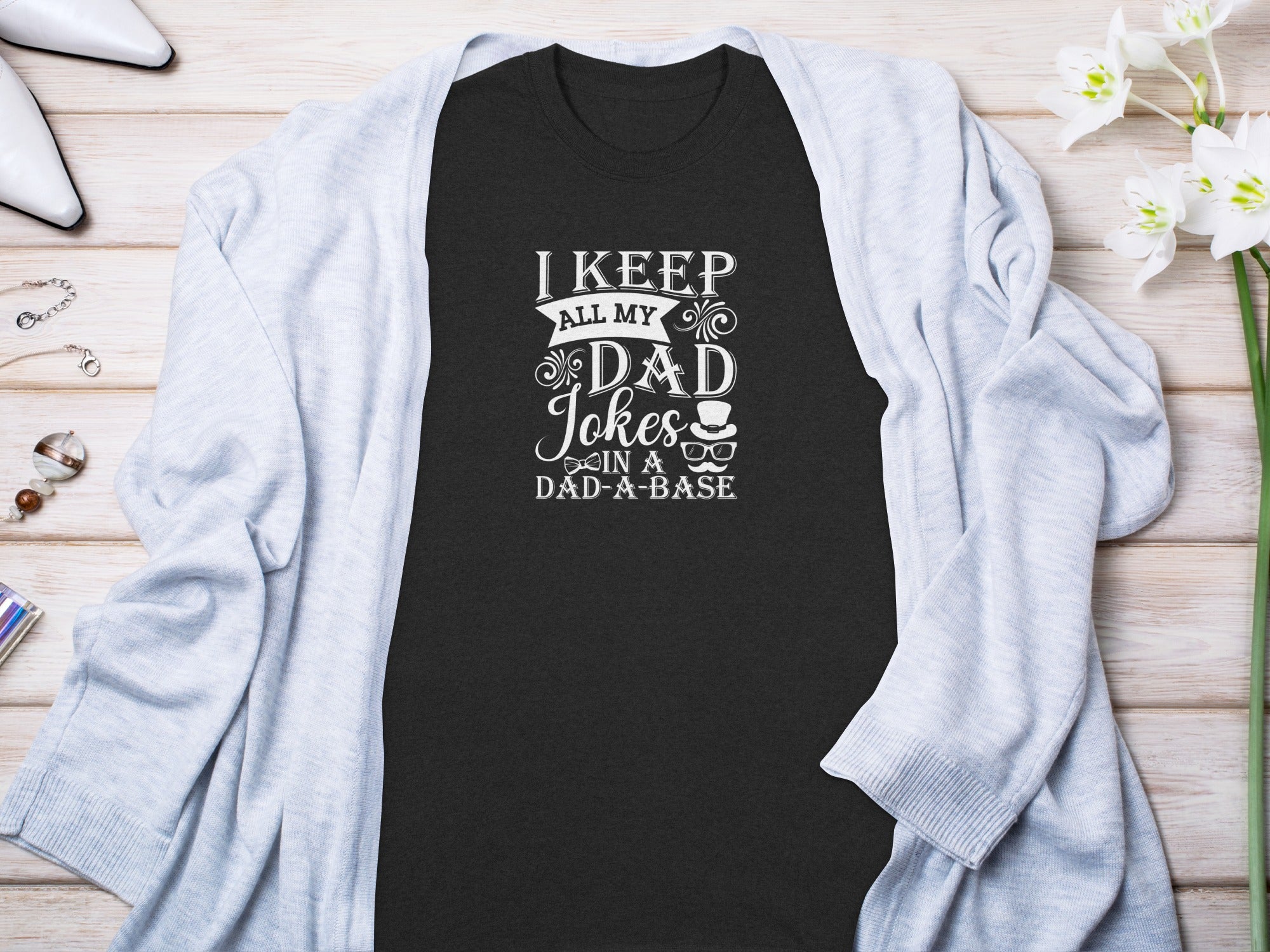 Black t-shirt with white text reading "I KEEP ALL MY DAD Jokes IN A DAD-A-BASE".