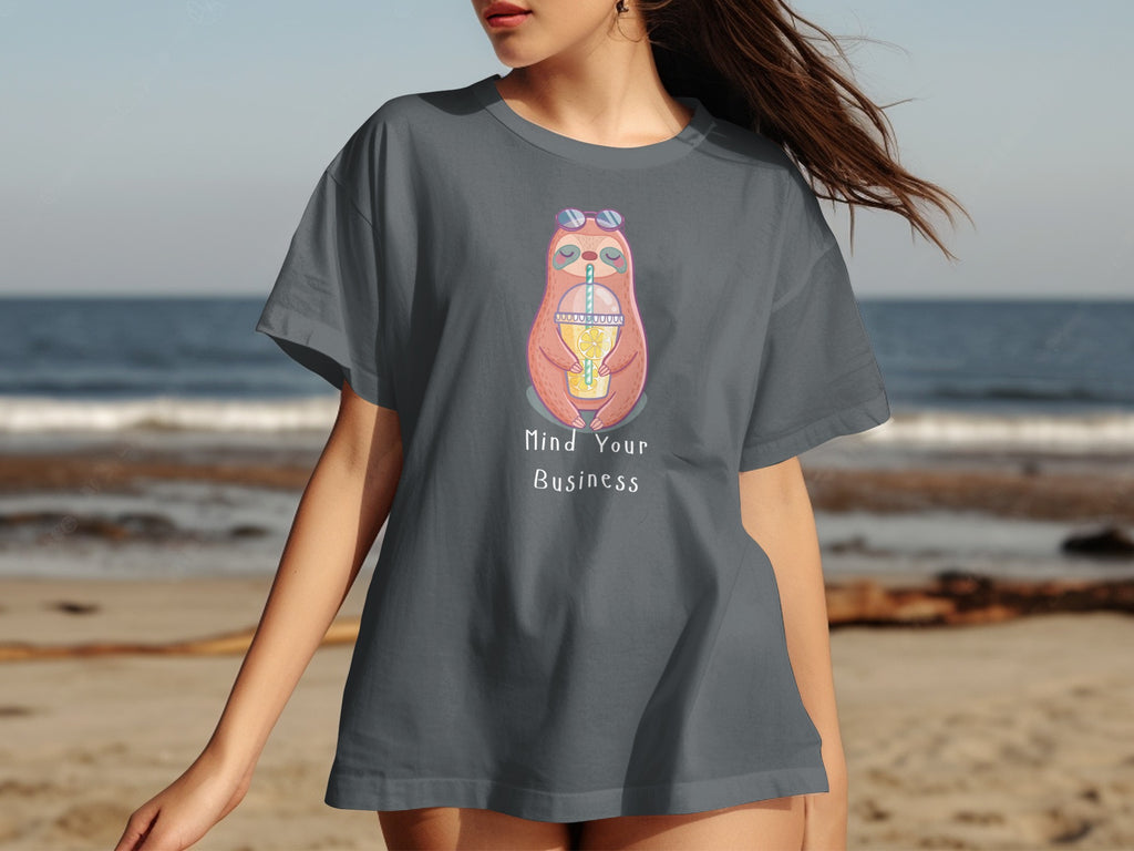 Grey t-shirt with pink sloth illustration holding lemon drink and text "Mind Your Business".