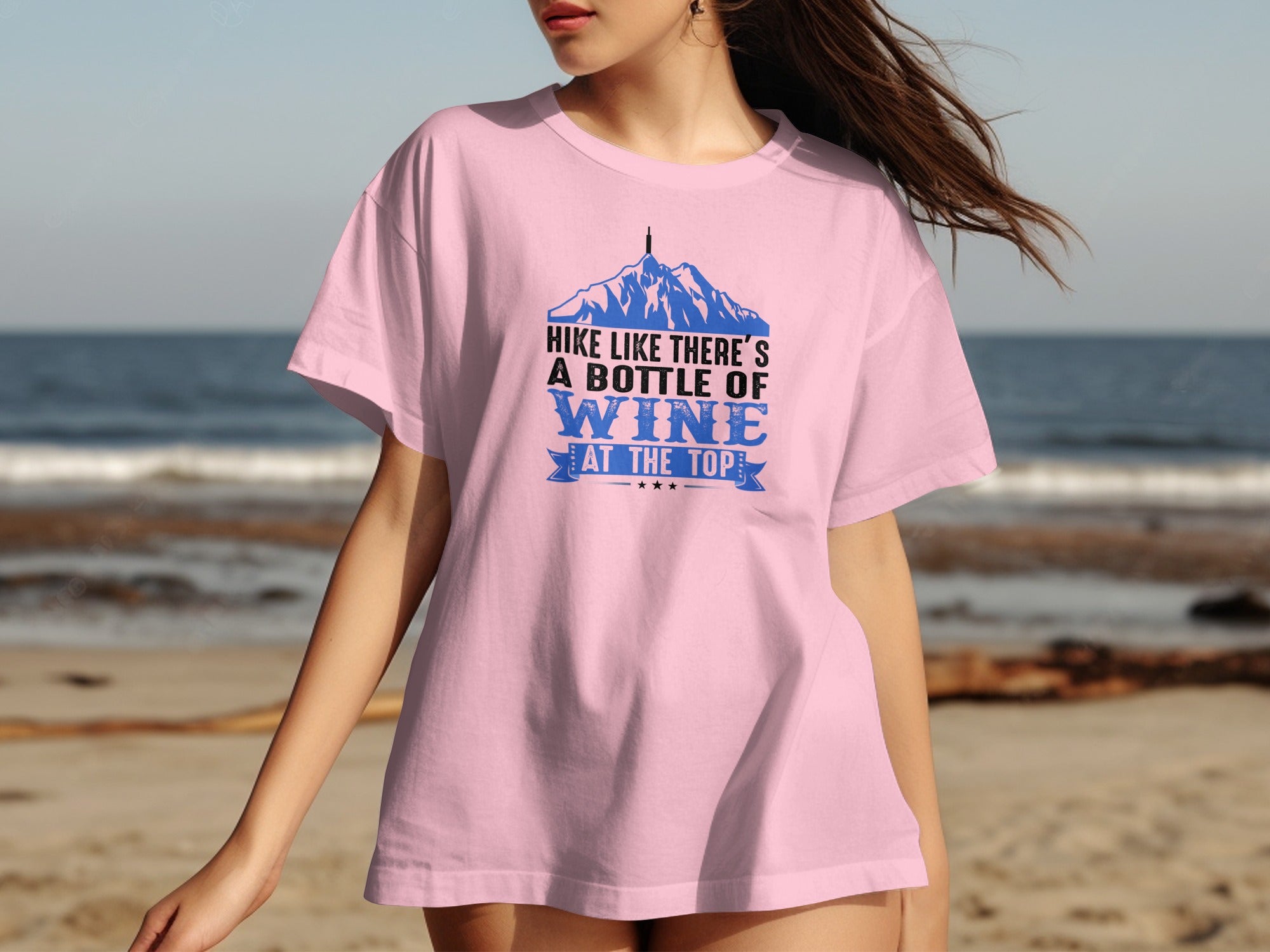 Pink t-shirt with mountains and text: "HIKE LIKE THERE'S A BOTTLE OF WINE AT THE TOP"