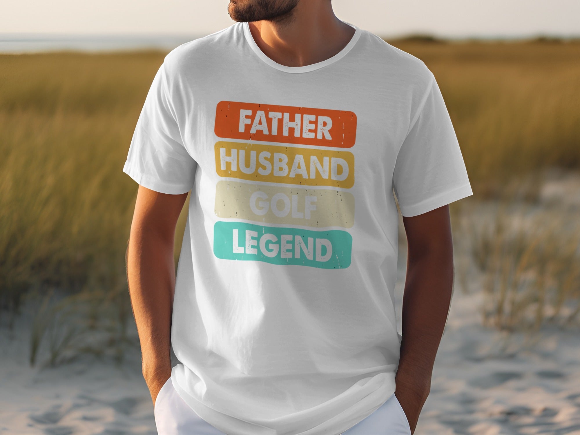 White t-shirt with text "FATHER HUSBAND GOLF LEGEND" in colorful blocks.