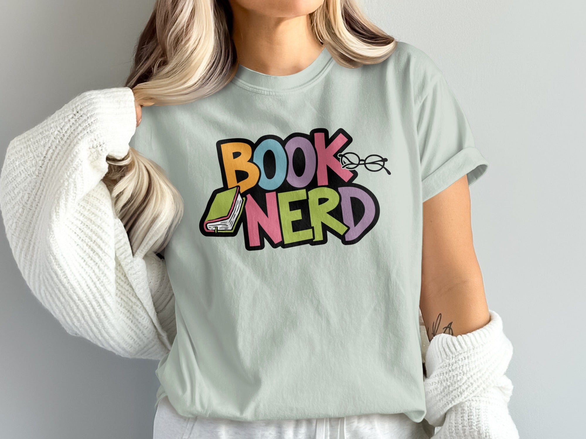 Light green t-shirt with colorful "BOOK NERD" text and glasses graphic.
