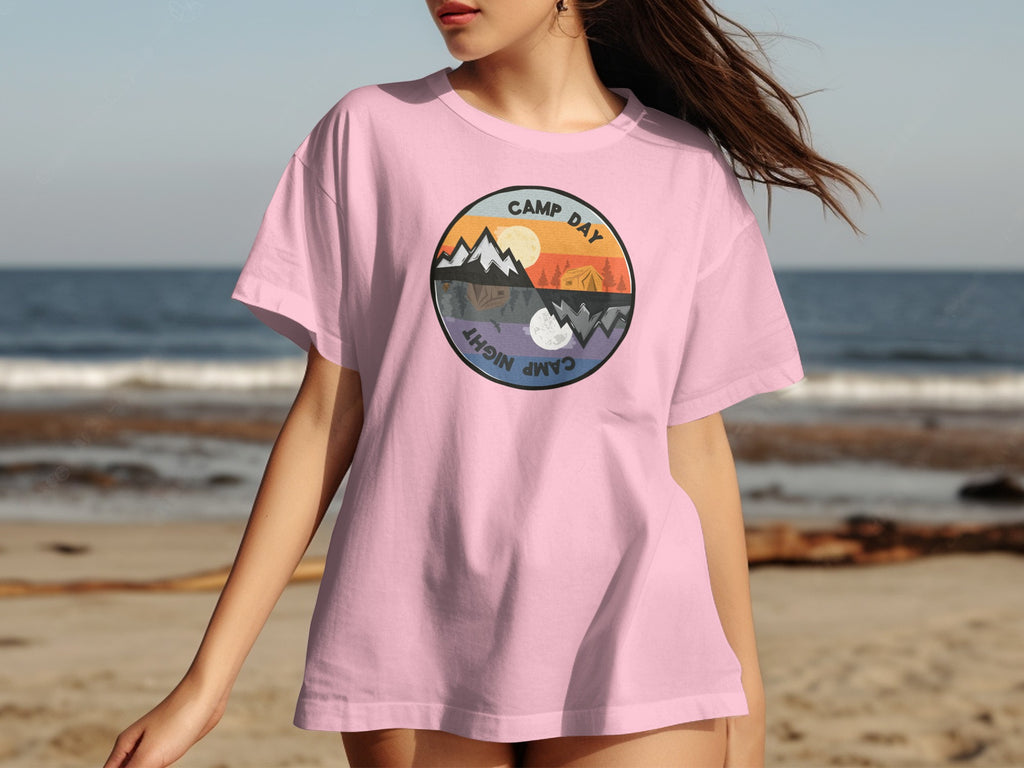 Pink t-shirt with a circular graphic depicting day and night camping scenes.