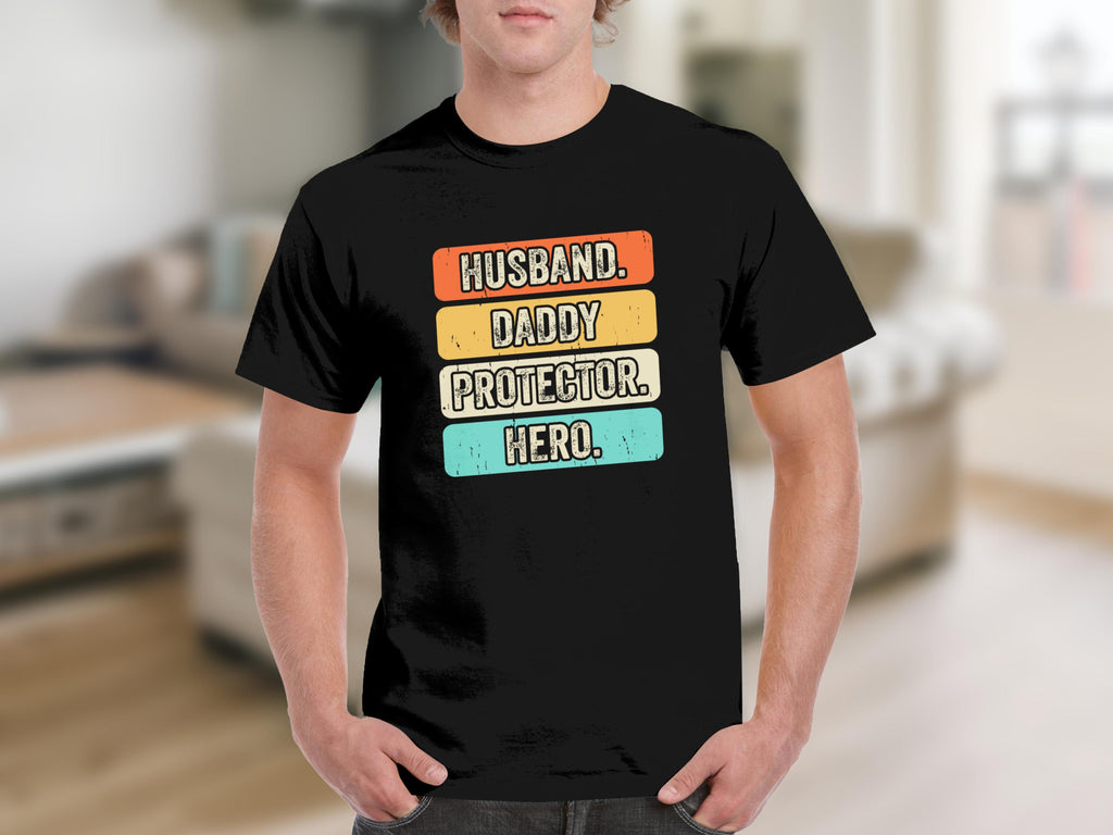 Black t-shirt with text "Husband, Daddy, Protector, Hero" in retro style.