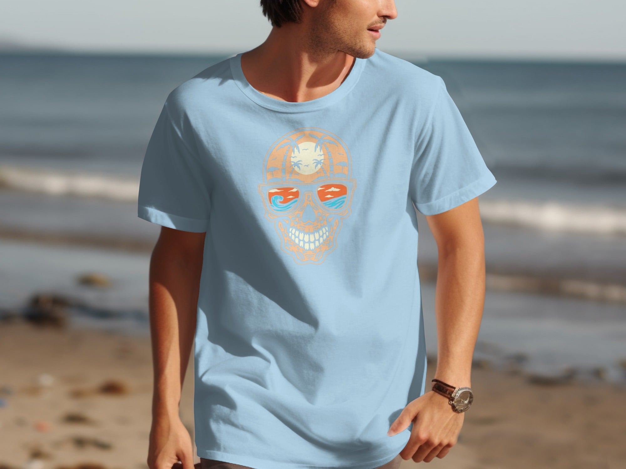 Light blue t-shirt with skull graphic wearing sunglasses on a beach.