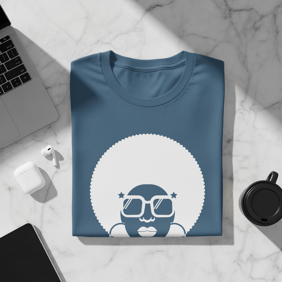 Blue t-shirt with a white graphic of a person with an afro and sunglasses.