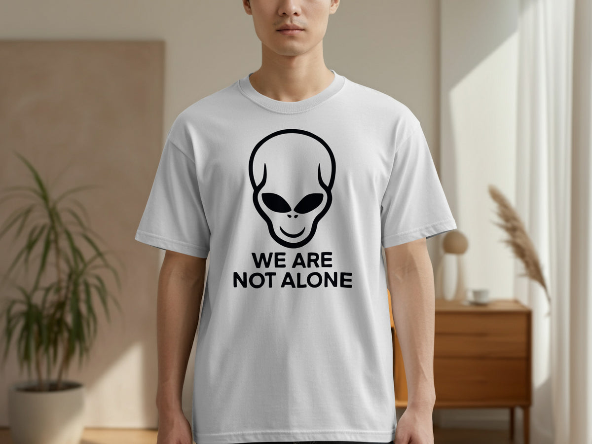 White t-shirt with black alien graphic and text "WE ARE NOT ALONE".