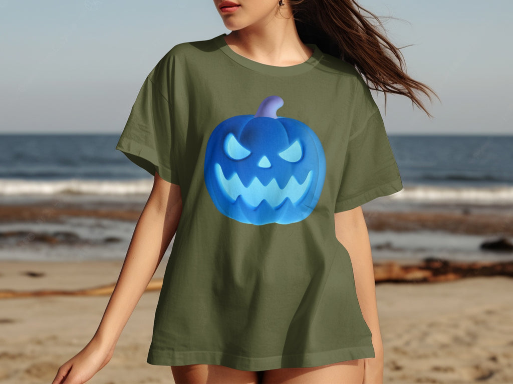 Green t-shirt with a neon blue jack-o'-lantern graphic on a beach.