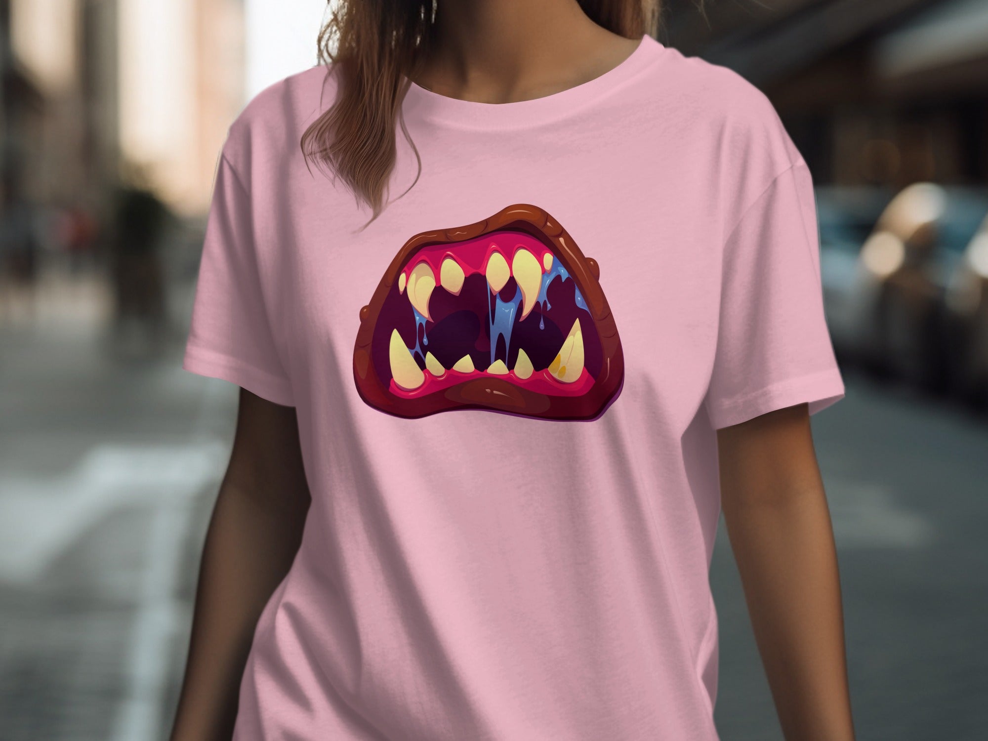 Pink t-shirt with a graphic of cartoon monster teeth and dripping blue saliva.