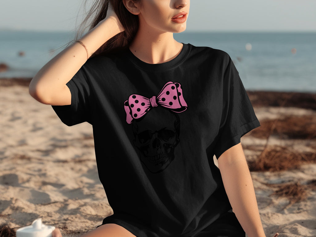 Black t-shirt with a skull graphic and pink polka dot bow on the chest.