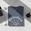 T-shirt with "My Weekend" text and flower graphic, with laptop and earbuds.