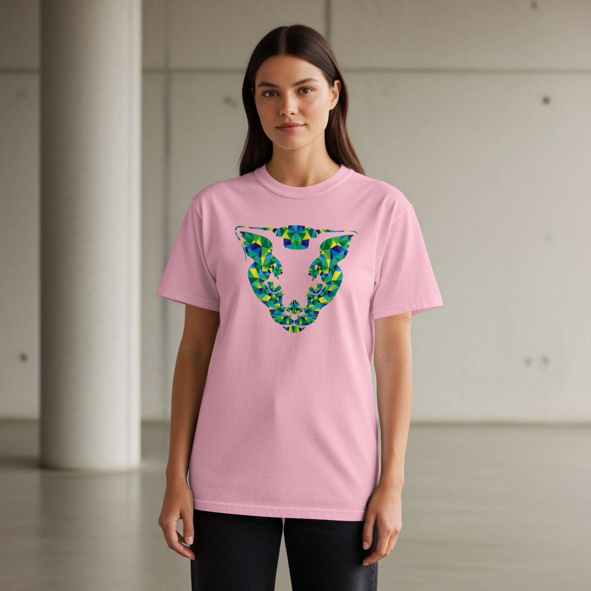 Pink t-shirt with a geometric blue, green, and yellow abstract animal head graphic.