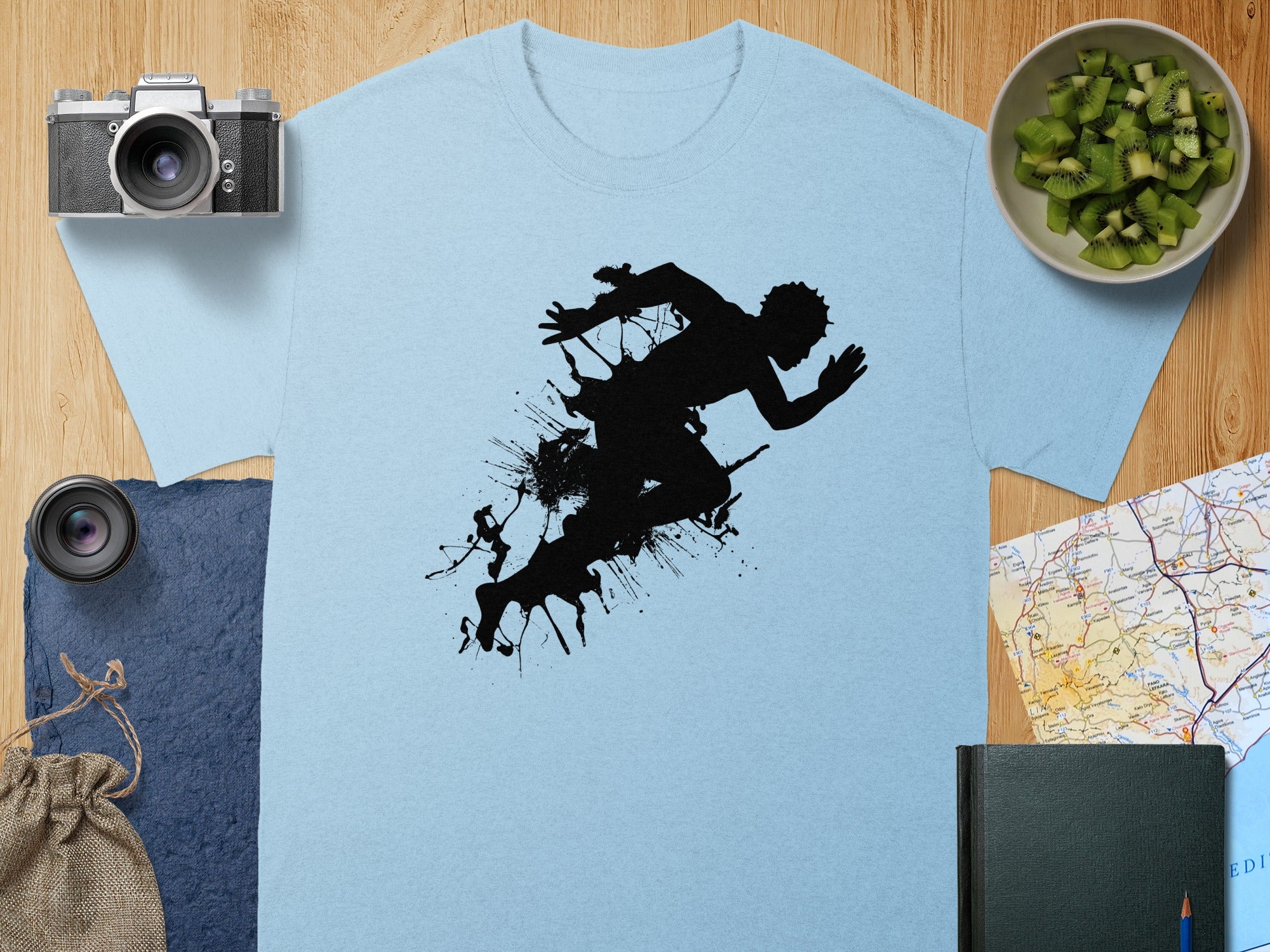 Light blue t-shirt with black silhouette of a runner with paint splatters.