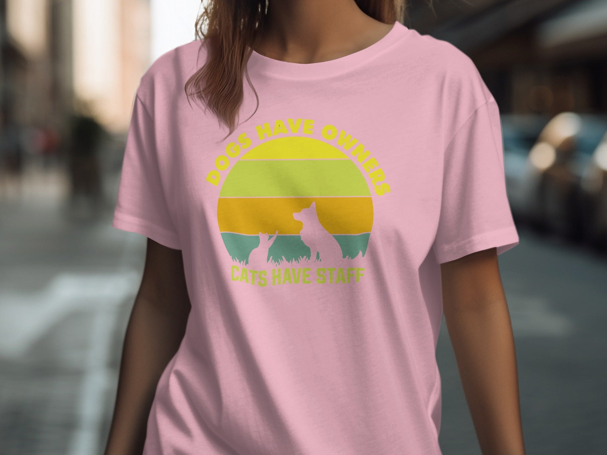 Pink t-shirt with "DOGS HAVE OWNERS CATS HAVE STAFF" graphic and sunset silhouette.