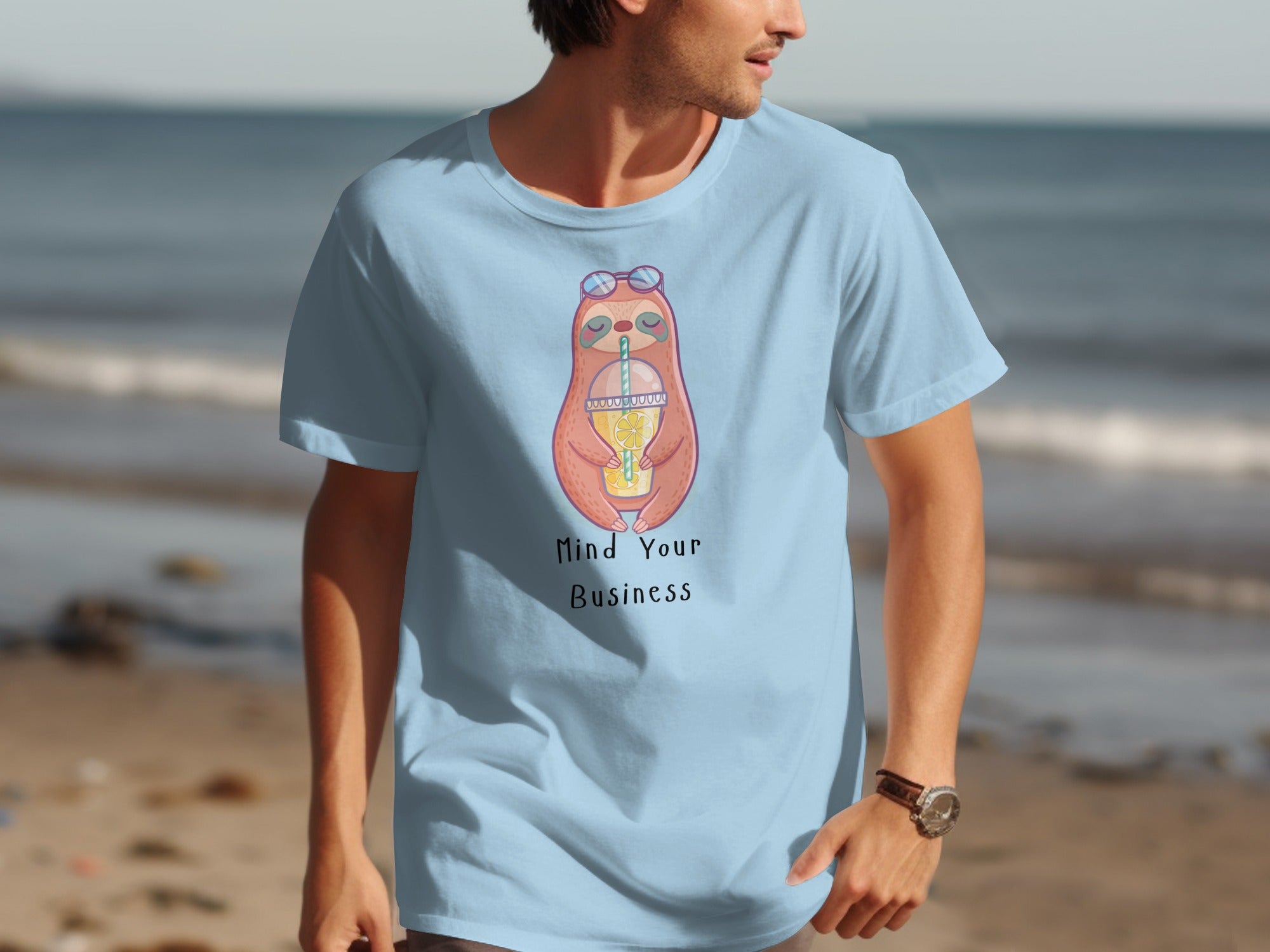 Light blue t-shirt with a cartoon sloth drinking lemonade and text "Mind Your Business."