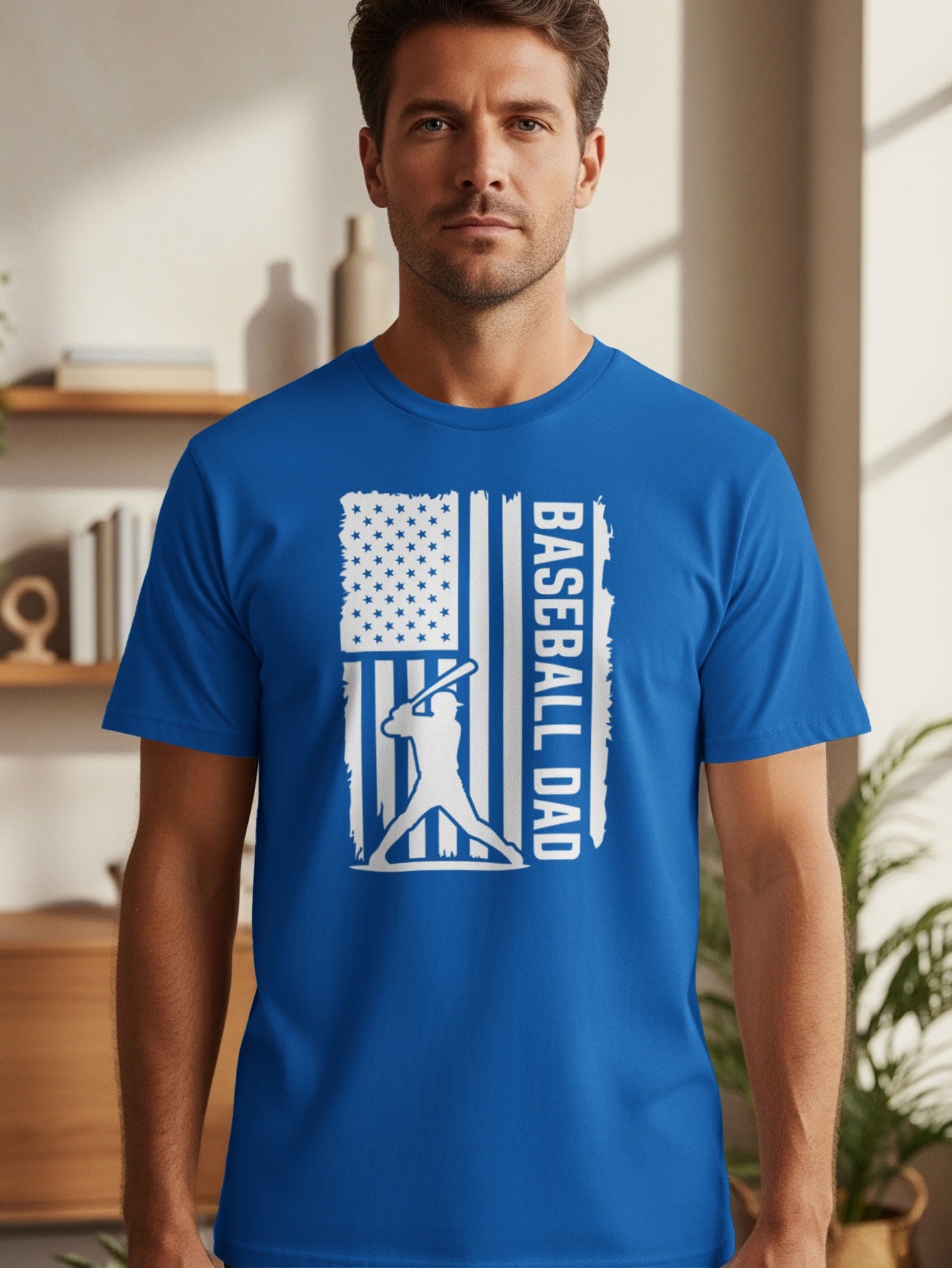 Blue t-shirt with white graphic of American flag, baseball player, and text "BASEBALL DAD".